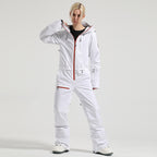 Front view of a model wearing the white Alpine Access one-piece ski suit with contrasting orange zipper trim.